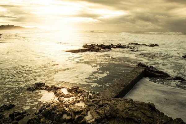 Image des vagues avec des récifs sur fond de coucher de soleil