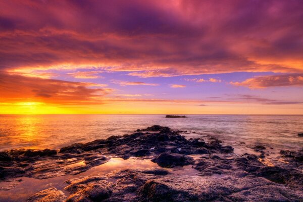 Mar en el fondo del amanecer con piedras