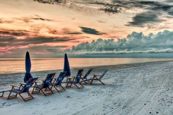 Sun loungers on the beach against the sunset