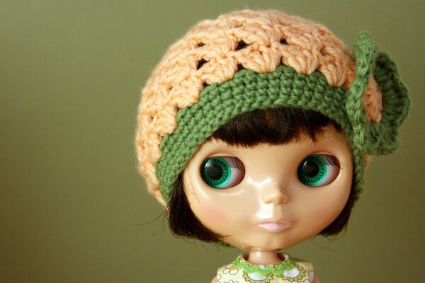 A doll in a hat with green eyes