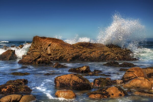 Las olas golpean las piedras. Mares