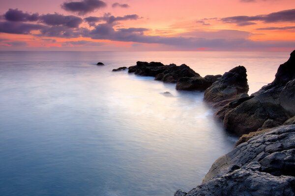 Puesta de sol sobre la costa rocosa del mar