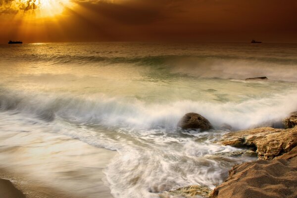 Pôr do sol e ondas na costa rochosa