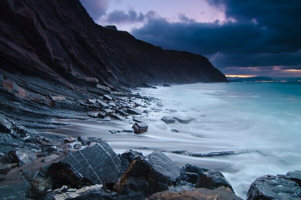 Foam waves are beating against the sea cliff