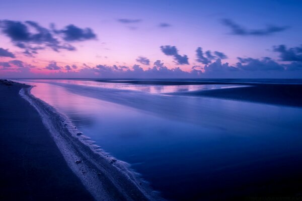 Der rosa Sonnenuntergang spiegelt sich im Meer wider