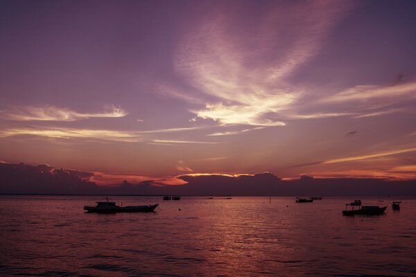 Purpurroter Sonnenuntergang. Boote und Schiffe auf See