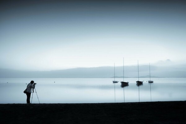 Photographer on the sea beach shoots a beautiful landscape