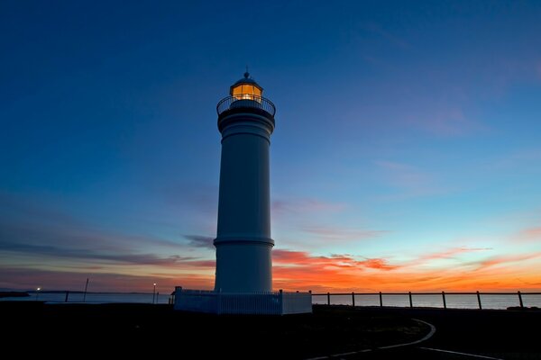 Faro junto al mar por la noche