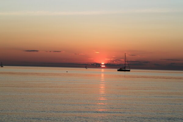 Boats on the sea surface in the light of the setting sun