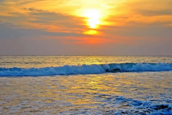 Sunset over the foaming sea waves