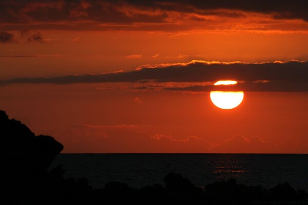 Sunset on a full moon. the moon behind the clouds