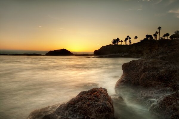 Pôr do sol no oceano no nevoeiro