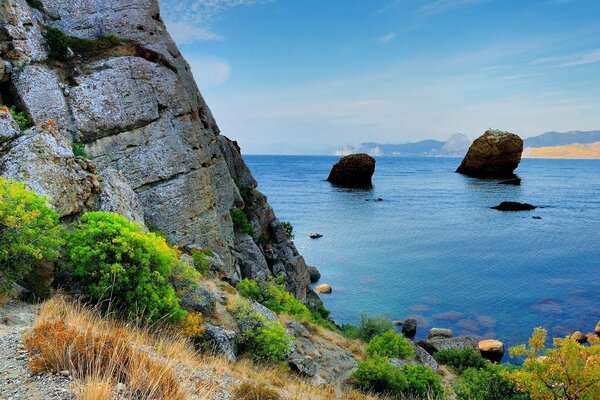 Mountains rocks in the water horizon sky greenery