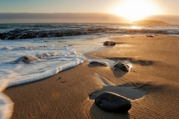 The sandy beach is covered with rocks