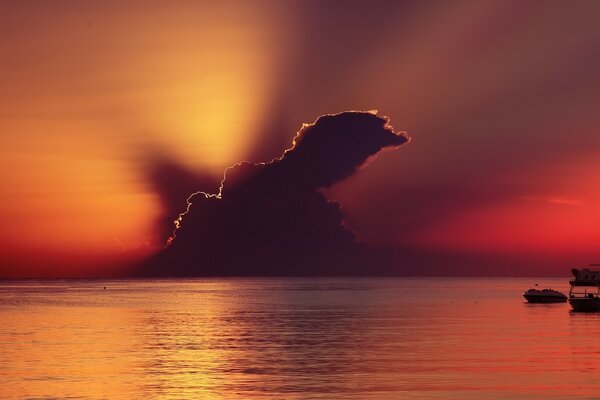 Puesta de sol en el mar con una nube gris