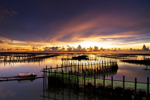 Sunset and reflection of water in the ocean with fences