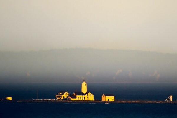 Leuchtturm und Häuser auf einer Insel mitten im Meer