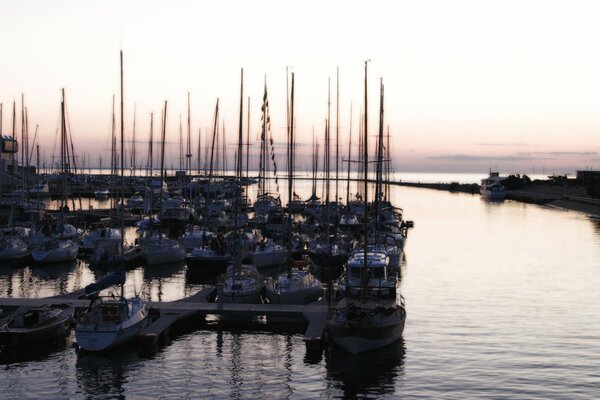 Parking de yacht dans la baie après le coucher du soleil