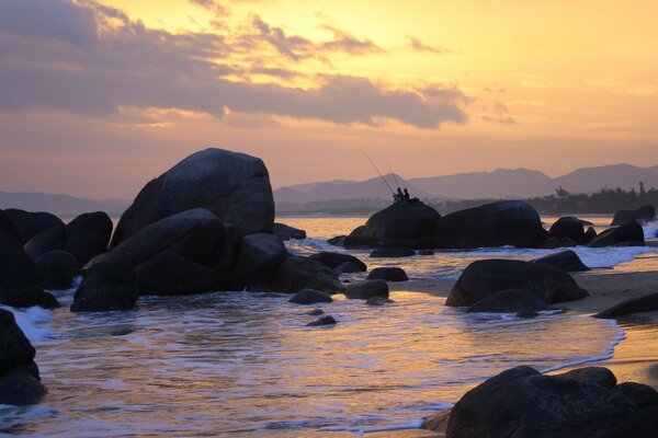 Beau coucher de soleil sur la rive rocheuse