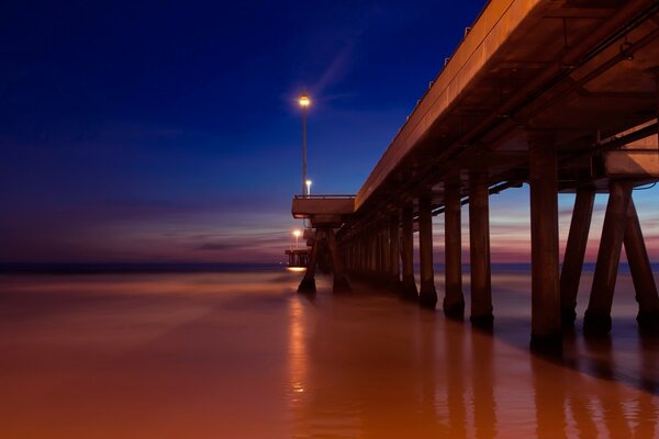 Puente iluminado por Fanari sobre el agua de mar