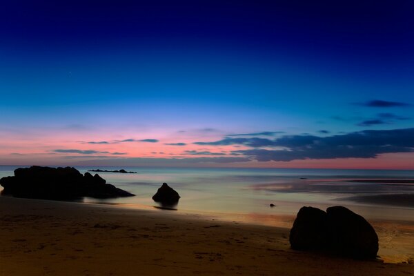 Spiaggia serale del mare ai raggi del tramonto