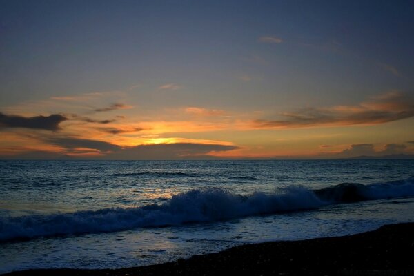 Pequeña puesta de sol sobre el mar azul