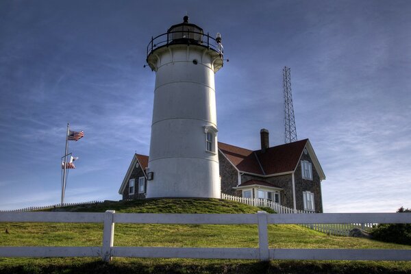 Lighthouse and house on the green edge