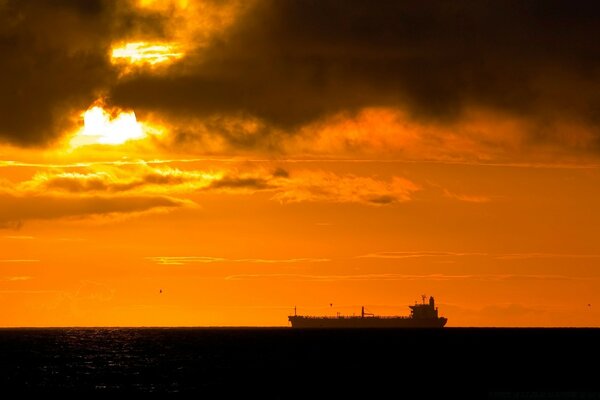 Silhouette eines Lastkahns in der Ferne vom Meer