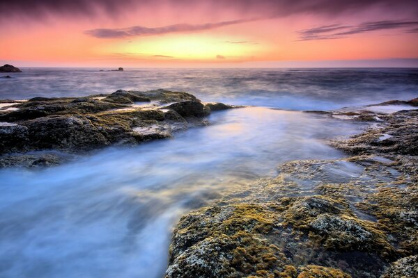 La oscuridad de las rocas sobre las aguas del océano