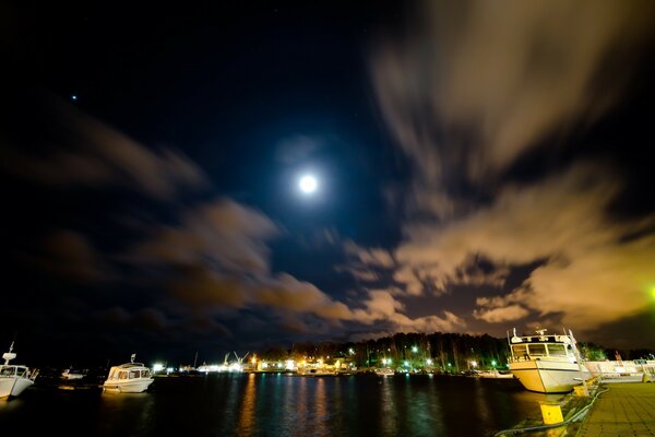 Der Mond beleuchtet das Wasser am Pier