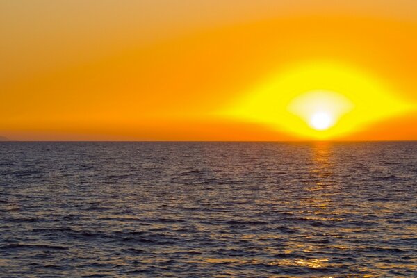 Orange sunset over the quiet surface of the water