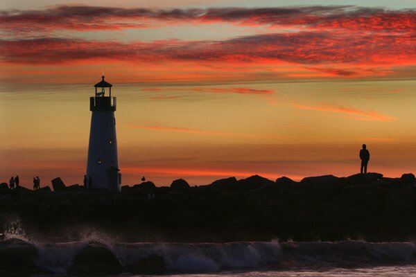 Silhouette de l homme et le phare sur fond de ciel