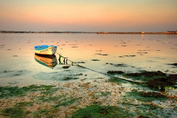 Sunset and boat that are reflected in the ocean