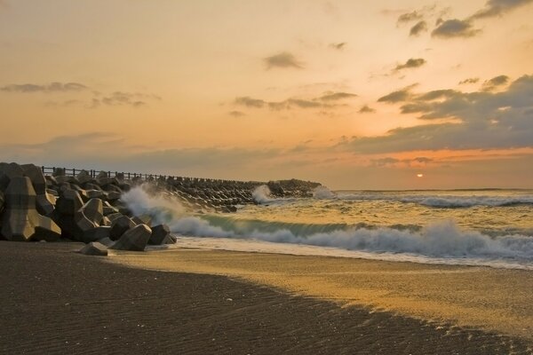 A wave hits the rocks on the shore