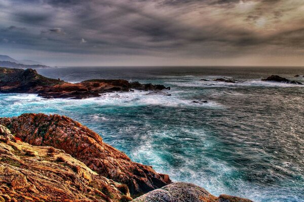 Costa rocciosa con distesa di mare