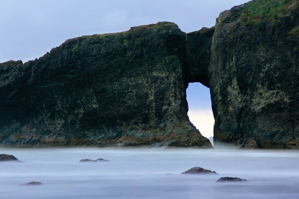 Ponte di roccia nell oceano nebbioso