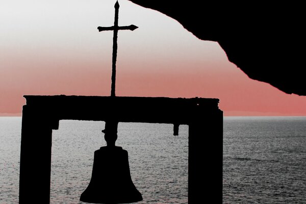 A bell in the ocean. The sea coast at sunset