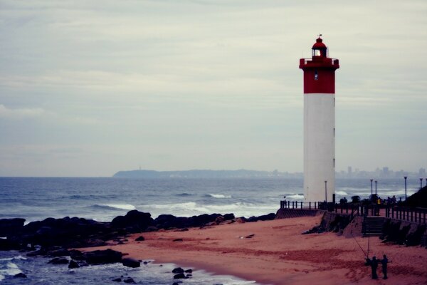 A lonely white-red lighthouse on the seashore