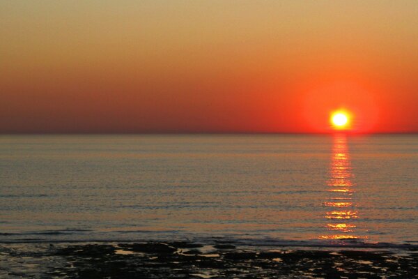 The evening sunset is reflected in the sea