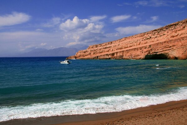 El mar azul y el cielo, la playa y la cueva de la roca