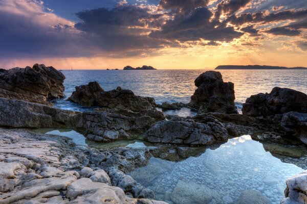 Meer und Ozean. Steine und Sonnenuntergang