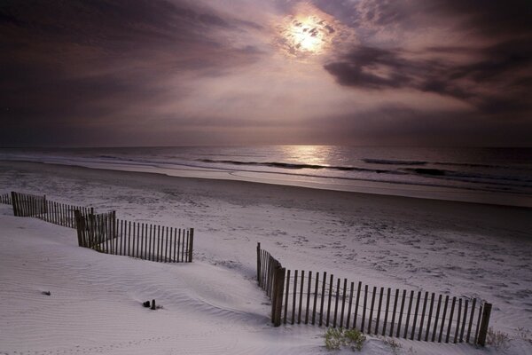 The beach in the snow, the sun through the clouds