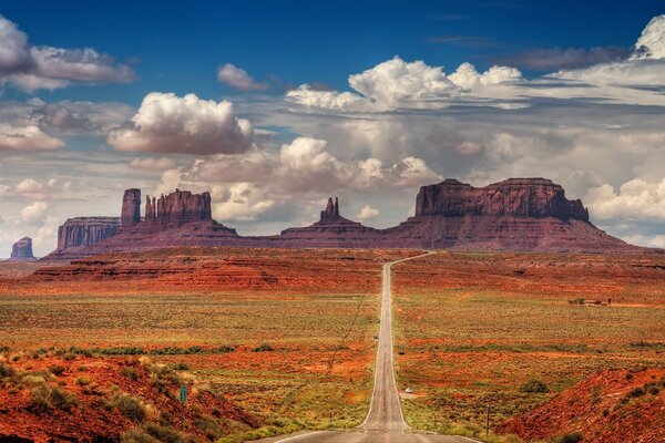 Die Straße führt in die Ferne große Sandsteinwolken