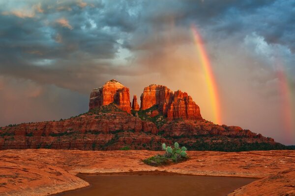 Regenbogen am Himmel und Sonnenuntergang in der Wüste