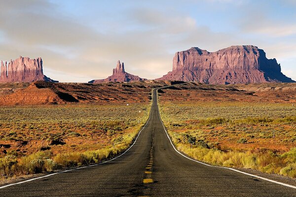 The road leads to the desert mountains