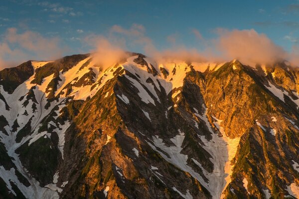 Schneebedeckte Berge mit orangefarbenem Sonnenuntergang