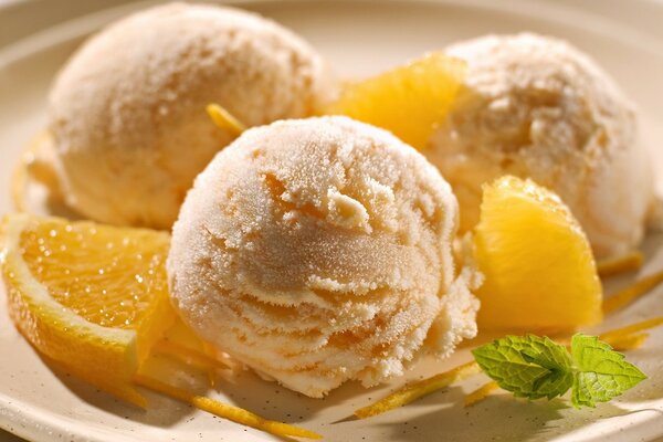 एक प्लेट पर संतरे और टकसाल के साथ आइसक्रीम