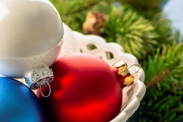 Bolas de Navidad en una canasta contra el fondo de ramas de abeto