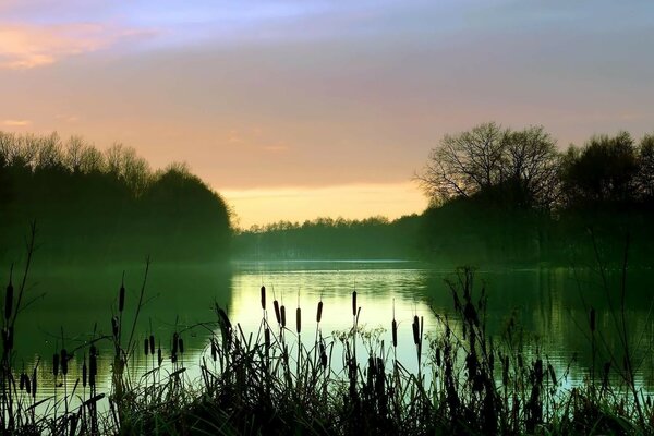 Puesta de sol sobre el lago silencioso, en la superficie del agua fantasmal