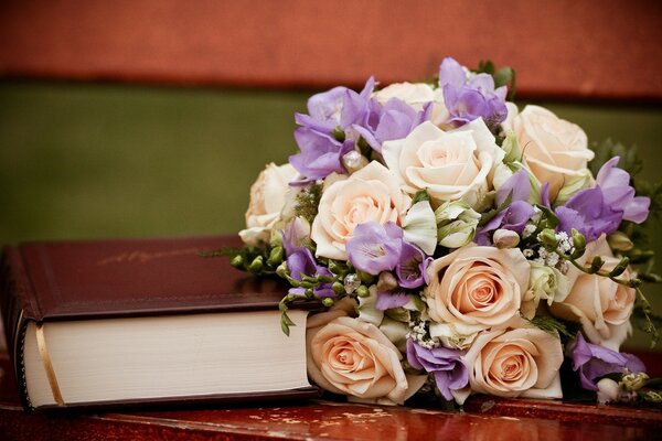 Beautiful bouquet of flowers with a book on the bench